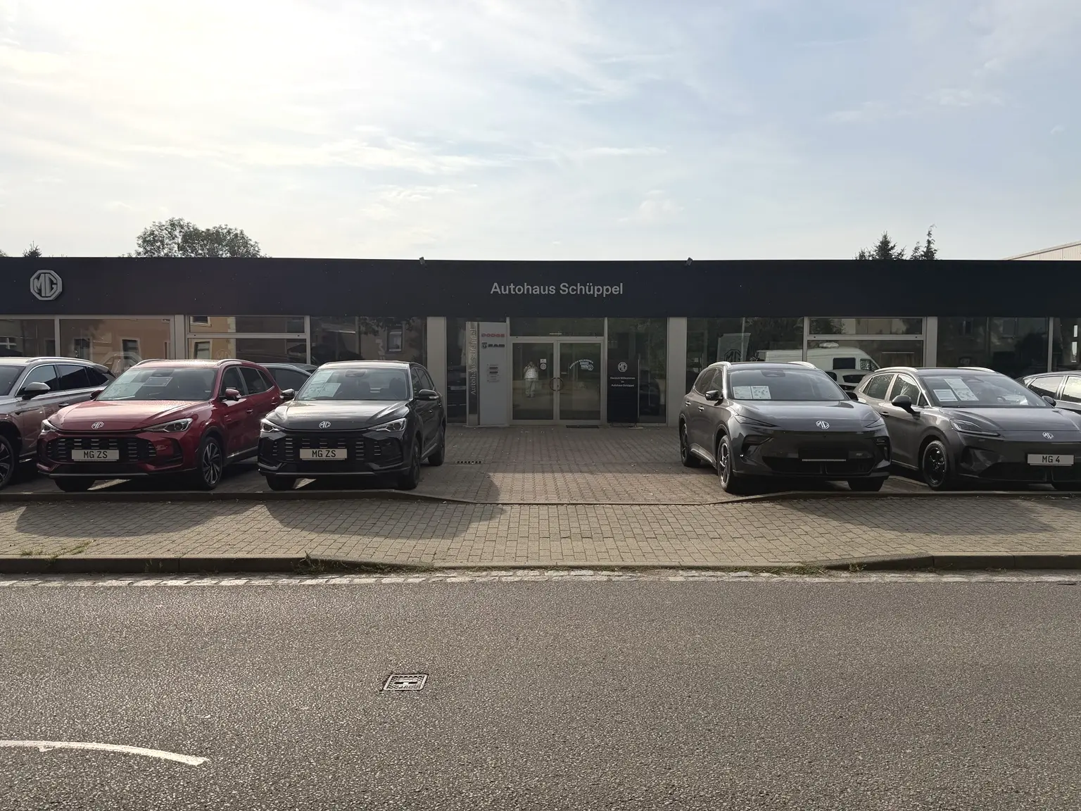 Haupteingang des Autohauses Schüppel in Burgstädt mit MG Fahrzeugen