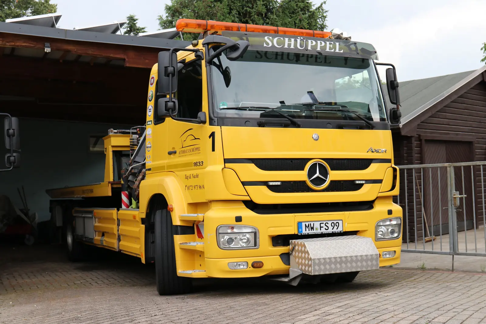 Gelber Schüppel Abschleppwagen vor der Fahrzeughalle